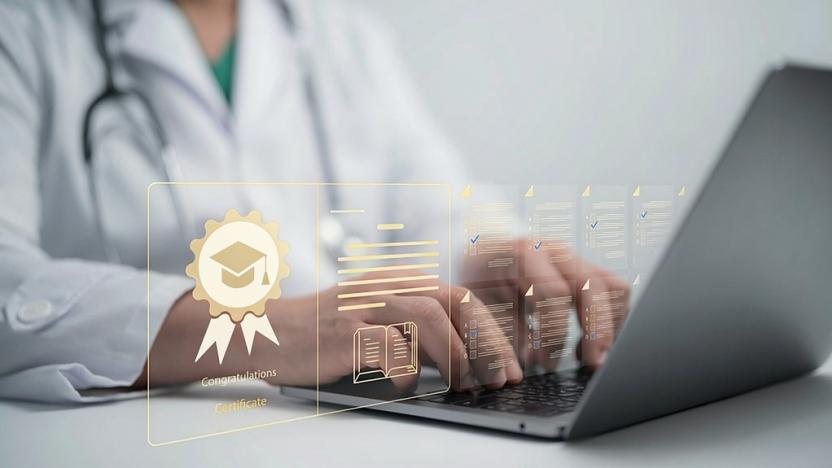 Person in white lab coat with stethescope around their neck types on a laptop. Holographic imagery of check-marked lists and a virtual badge appear as a layover graphic, as if emerging from the computer.