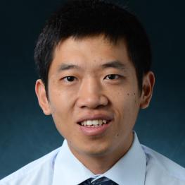 Kevin Lu wears a dress shirt and tie while smiling at the camera.